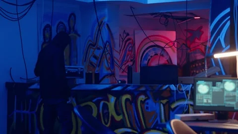 Hacker arriving in underground base, looking at spray cans Stock Footage 319548584