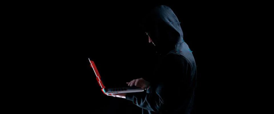 Hacker attack cyber security. Digital laptop in hacker man hand isolated on b 写真素材
