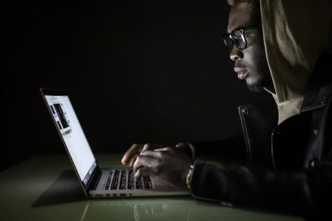 Hacker attack the server in the dark. Afro american hacker hack server from l Stock Photos
