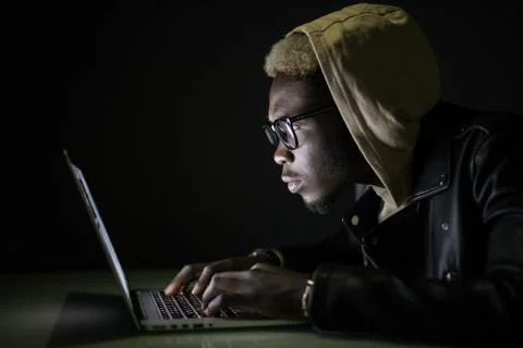 Hacker attack the server in the dark. Afro american hacker hack server from l Stock Photos