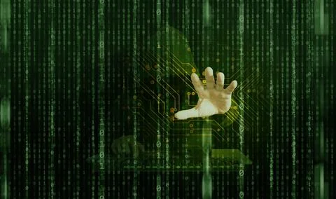 A hacker behind binary code able to break through cyber security 库存照片