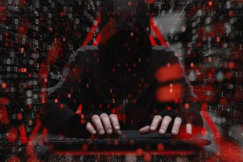 Hacker behind a computer. Concept of cybersecurity threat, attacks on data an Stock Photos