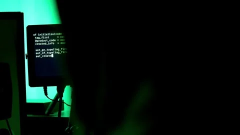Hacker in black goodie over the shoulder, typing code, writing code on dark Stock Footage 297674884