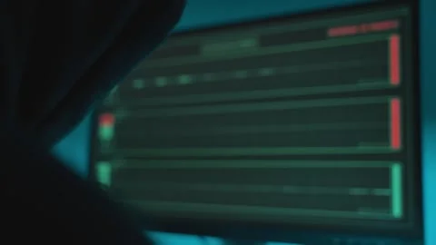 Hacker with black hoodie looking at computer monitor with audio recording app Stock Footage 332657765