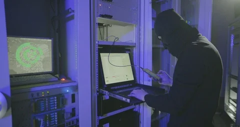 Hacker in black mask searches on server computer folders and files to copy Stock Footage 107340768