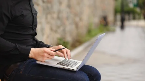 Hacker in black types info on modern smartphone and laptop Stock Footage 111611522