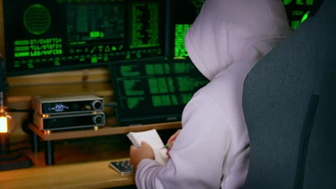 Hacker brainstorming and writing notes in moody dark tech room 60fps Stock Footage 312968385