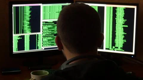 Hacker breaking code and drinking from the cup at your desk. Criminal hacker Stock Photos