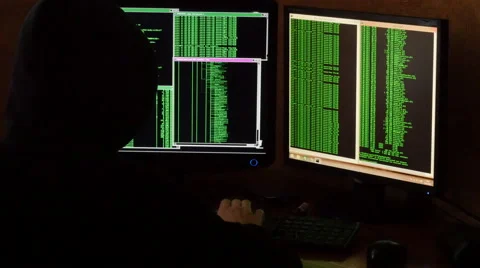 Hacker breaking code. Criminal hacker with black hood in dark room. Stock Footage 63088654