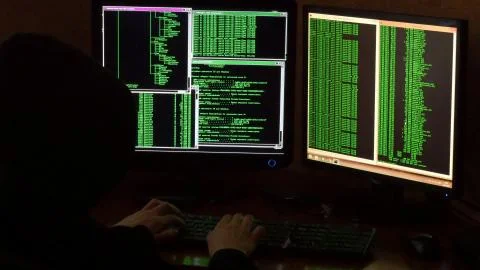 Hacker breaking code. Criminal hacker with black hood 스톡 사진