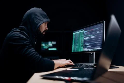 Hacker coding on computers Stock Photos