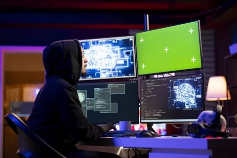 Hacker coding on green screen PC using machine learning to evade security Foto stock