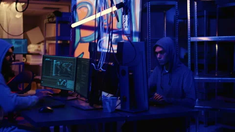 Hacker coding malware in dark room Stock Footage 256112183
