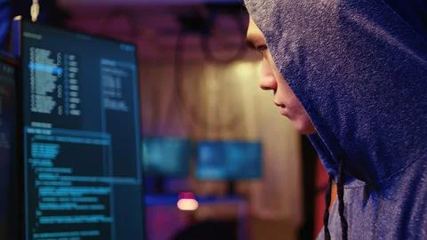 Hacker at computer developing spyware Stock Photos
