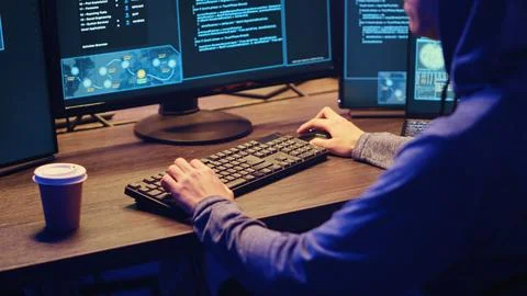 Hacker at computer running spyware Stock Photos