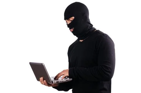 Hacker with computer wearing balaclava 스톡 사진