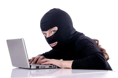 Hacker with computer wearing balaclava 스톡 사진