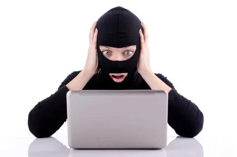 Hacker with computer wearing balaclava 스톡 사진