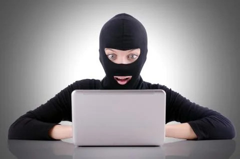 Hacker with computer wearing balaclava 스톡 사진