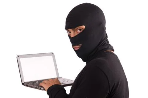 Hacker with computer wearing balaclava 스톡 사진