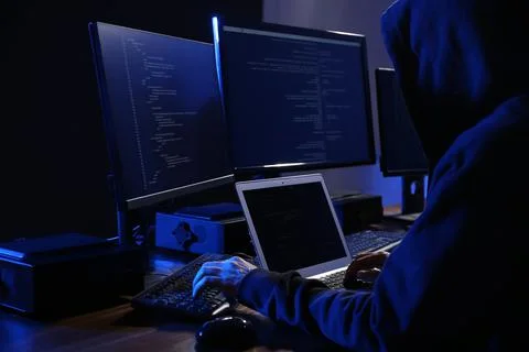 Hacker with computers in dark room. Cyber crime Photos