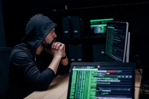 Hacker with computers indoors Stock Photos