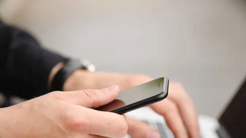 Hacker confirms transaction in smartphone types on laptop Stock Footage 111611467