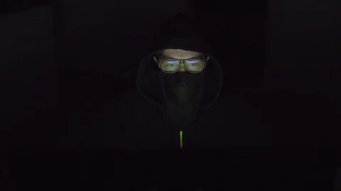 Hacker with a covered face is working on the computer. Stock Footage 105489599