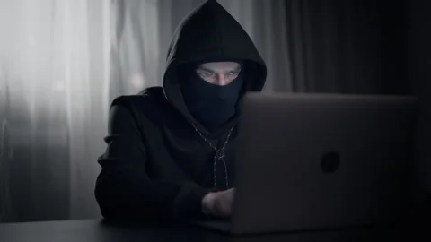 Hacker cracker in the hood in a dark room using computer virus program for cyber Stock Footage 138839926