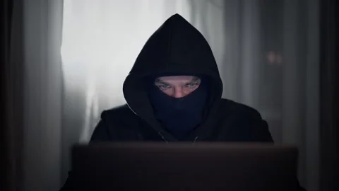 Hacker cracker in the hood in a dark room using computer virus program for cyber Stock Footage 138839946