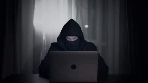 Hacker cracker in the hood in a dark room using computer virus program for cyber Stock Footage 138841704