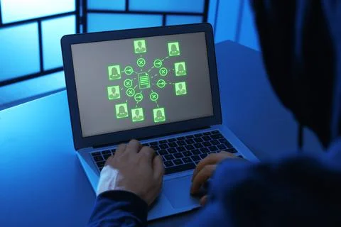 Hacker cracking access to documents using laptop Foto stock
