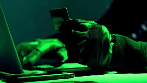 Hacker with credit card for online hack shopping using mobile banking on lapt Stock Footage 265927626