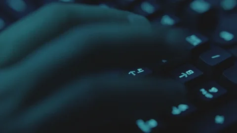 Hacker in the Dark Atmosphere is writing quickly on the keyboard while stealing Stock Footage 123018210