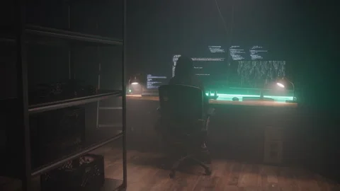 Hacker in Dark Clothes Steals Information on Computer at Desk in Basement Room Stock Footage 208787497