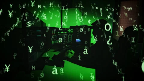Hacker in dark hoodie operating in green-lit room during cyberattack scene Stock Footage 323045190