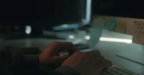 Hacker in dark office typing code Stock Footage 78037665