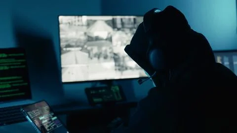 A Hacker in the dark room surrounded computer. Hacking and malware. Cyber crime. 库存照片