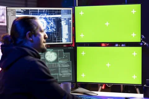 Hacker doing covert operations using green screen PC to bypass advanced security Stock Photos