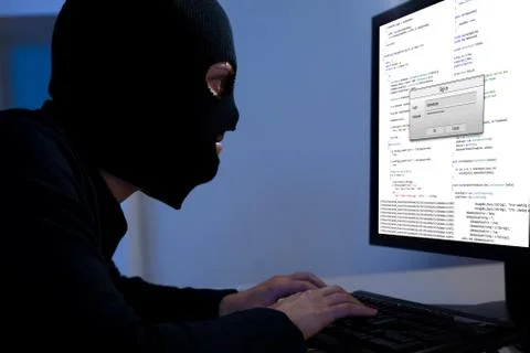 Hacker downloading information off a computer Stock Photos