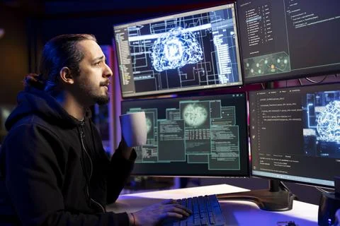 Hacker drinking coffee while doing ransomware attacks using AI Stock Photos