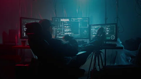 Hacker eating noodles while resting at desk with monitors Stock Footage 257382385
