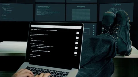 Hacker feet up to table. Hacker with laptop coding exploit to crack code. Man in Video stock 82889750