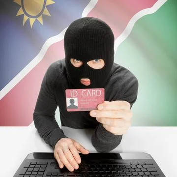 Hacker with flag on background holding ID card in hand - Namibia Hacker wi... Stock Photos