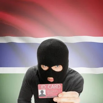 Hacker with flag on background holding ID card in hand - Gambia Hacker wit... 写真素材