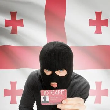 Hacker with flag on background holding ID card in hand - Georgia Hacker wi... Stock Photos