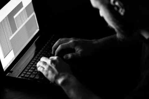 Hacker in front of his computer. Dark face 库存照片