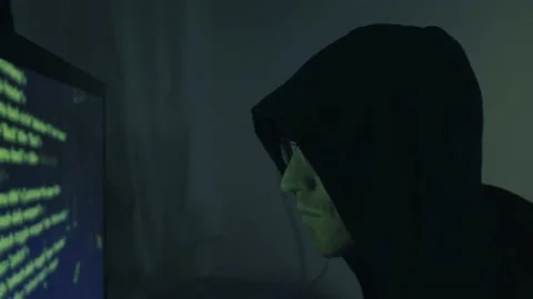 Hacker in front of his computer screen coding and hacking into security systems  Video stock 150436899