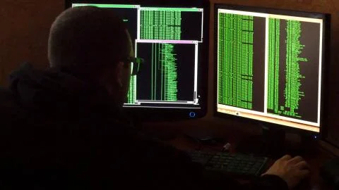 Hacker in glasses breaking code. Criminal hacker penetrating network system from 스톡 사진