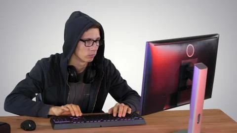 Hacker in glasses breaking code on gradient background. 写真素材